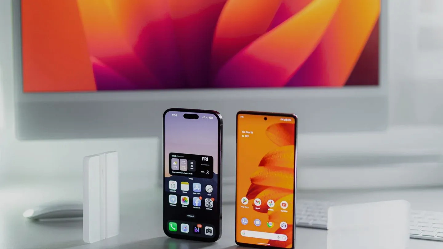 An iPhone and an Android phone standing side by side on a desk
