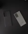 Smartphone, headphones, and game controller arranged on a dark desk