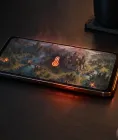 A landscape phone showing a thermometer warning, with heat shimmer and an unplugged cable nearby