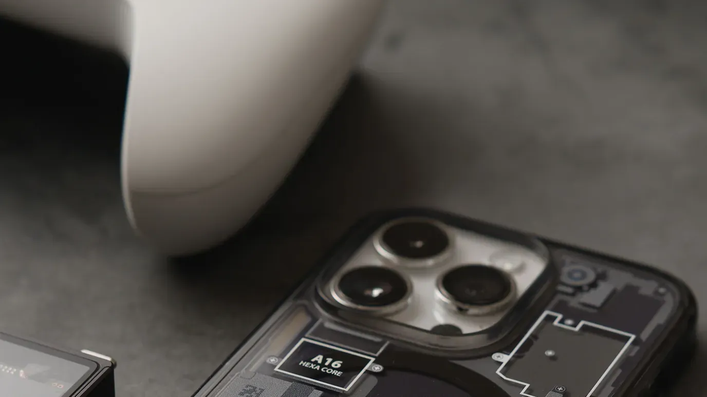 Smartphone and white game controller arranged on a dark tabletop