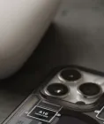 Smartphone and white game controller arranged on a dark tabletop
