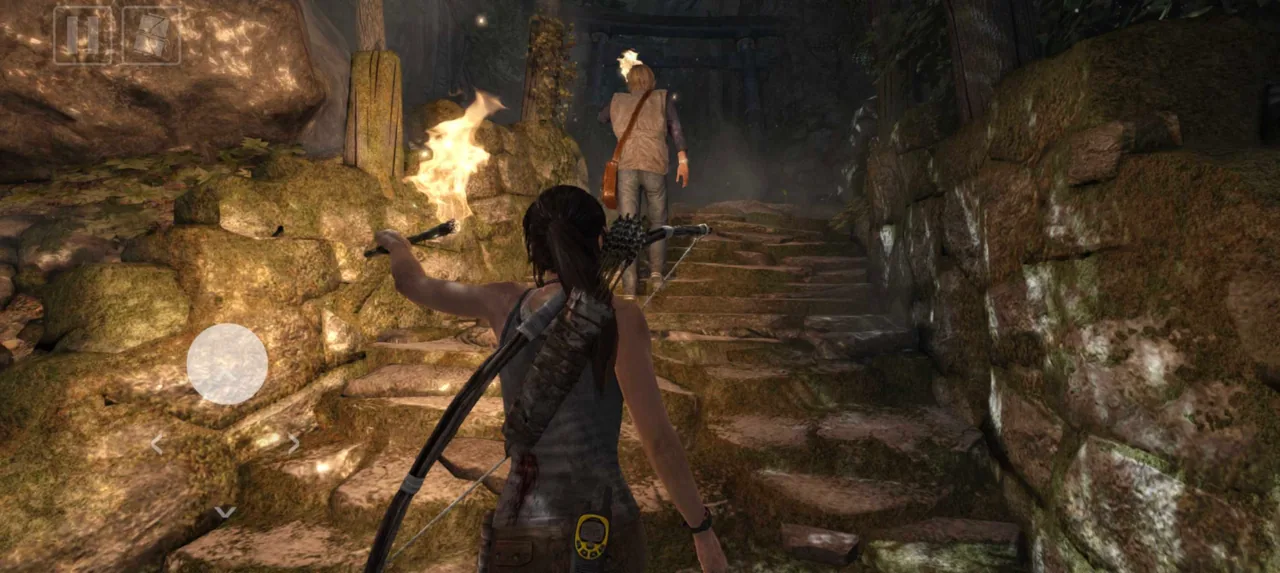 Lara Croft follows another survivor through torch-lit ruins using mobile touch controls